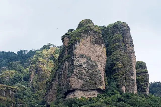 Sheer volcanic rock towers covered in forest